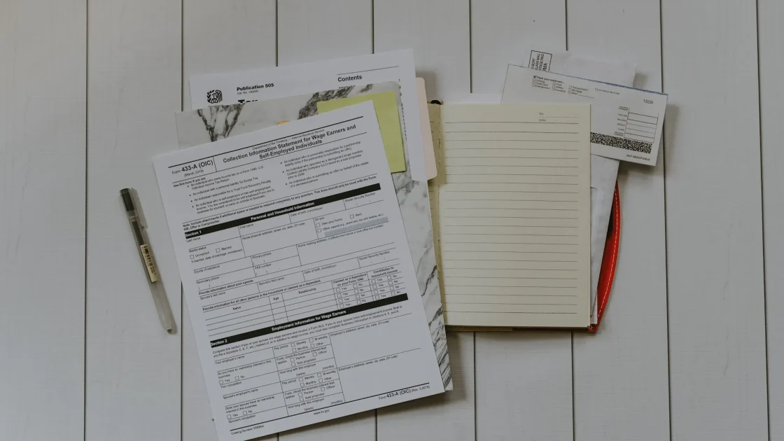 A repair estimate and insurance paperwork laid out on a desk beside a car key after a windshield claim.