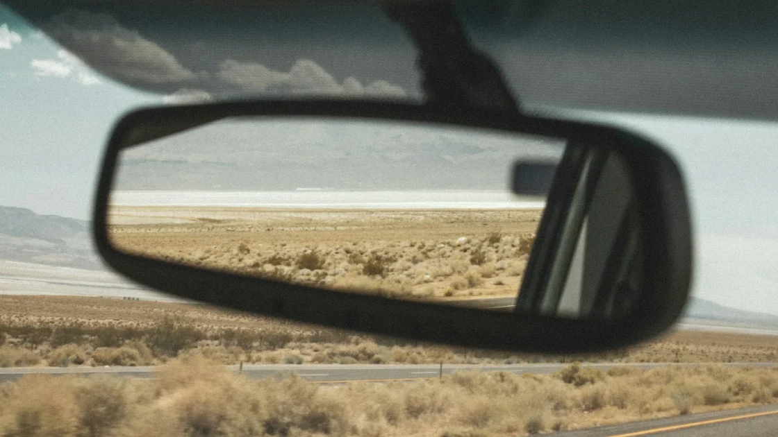 Forward-facing driver assist camera mounted behind a car rearview mirror with a driver assist not available message shown.