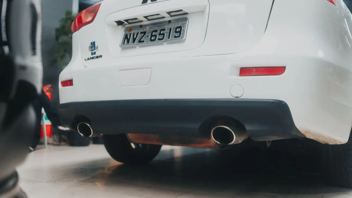 Rear corner of a car bumper with an internally mounted radar sensor detecting an approaching vehicle in the blind spot.