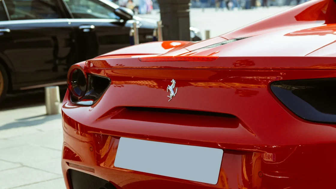 Rear bumper of a car with round ultrasonic parking sensors and a parking sensor warning symbol on the dashboard.