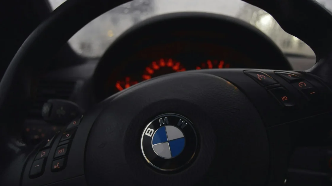A car instrument cluster showing a green lane keep assist symbol with two lane lines and a steering wheel.