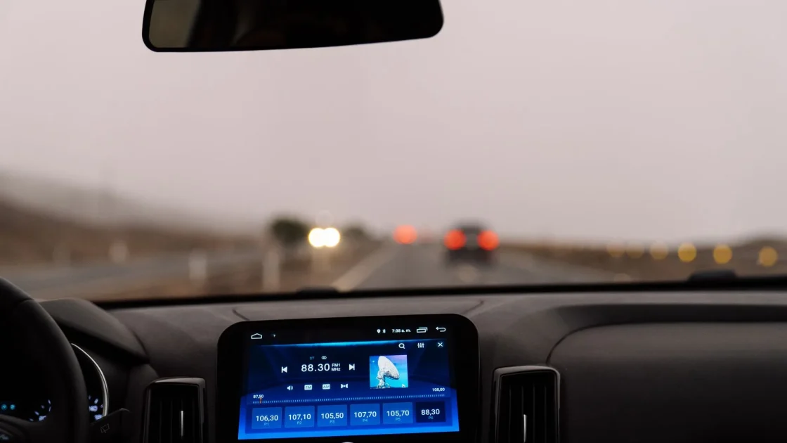 View from behind the wheel of a car driving at steady speed on a marked highway with the dashboard visible.