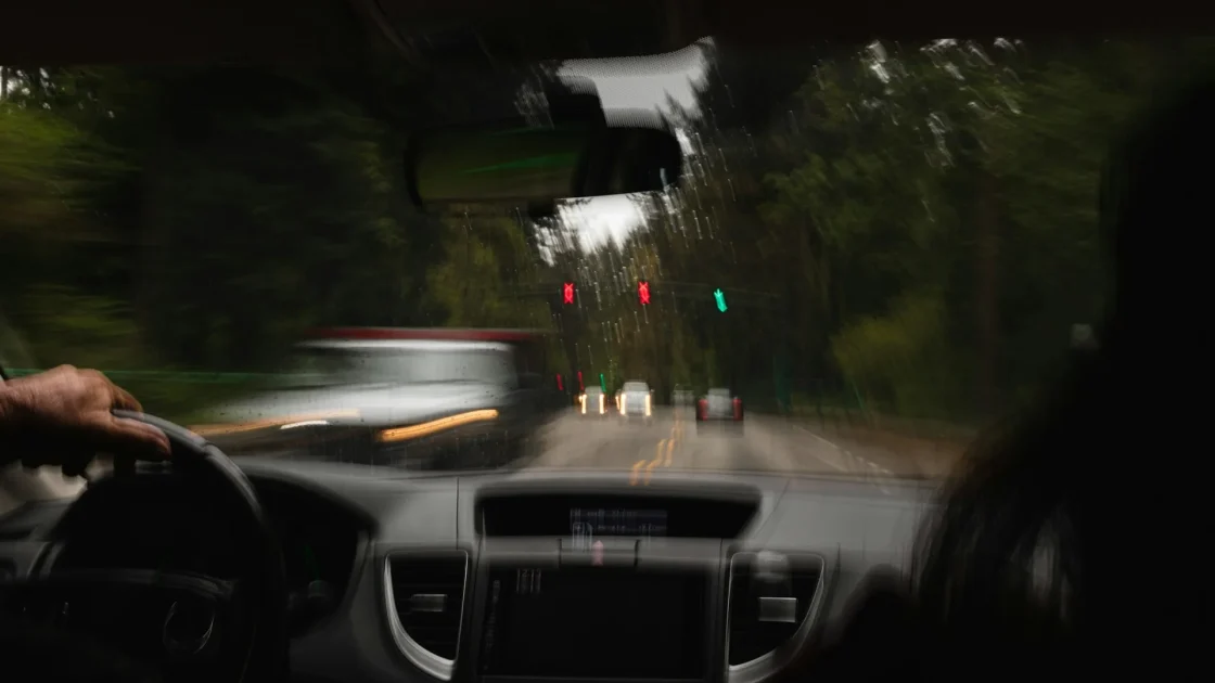 Driver hands on a steering wheel with a lane-centering assist indicator lit on the dashboard.