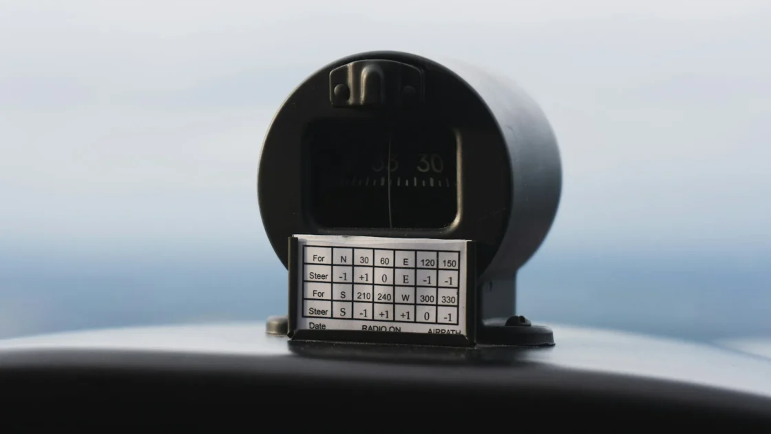 Close view of a forward-facing ADAS camera housing mounted behind a car's rearview mirror on the windshield.
