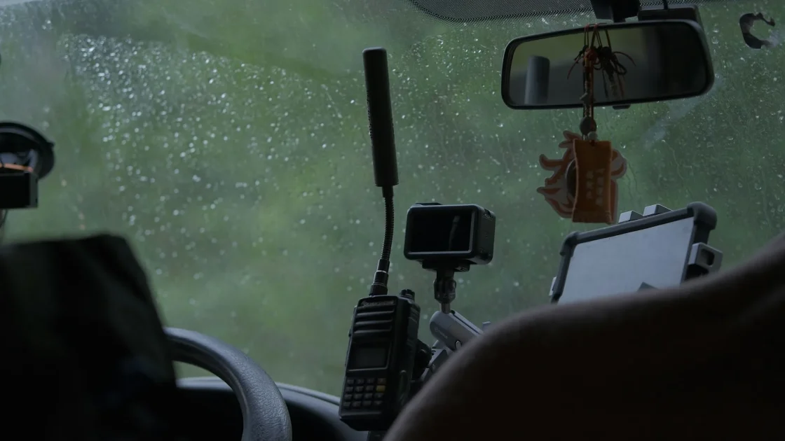 The forward-facing ADAS camera mounted behind a car's rearview mirror, viewed from inside the windshield.