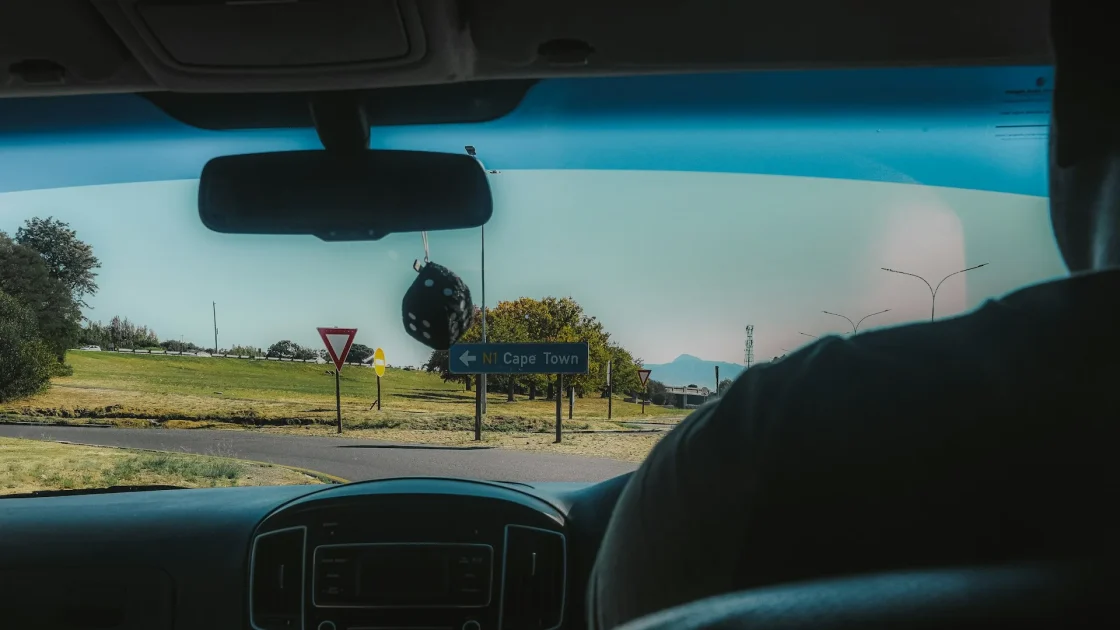 The forward-facing camera housing mounted on the windshield behind a car's rearview mirror, seen from inside.