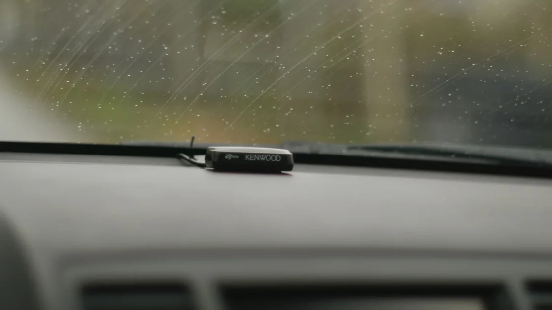 A cutaway view of a car showing the forward camera behind the windshield and radar sensors in the front bumper.