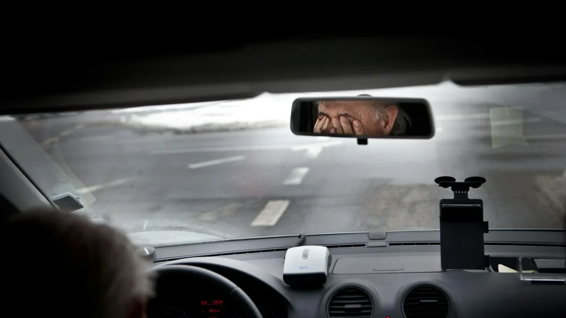 The black camera housing on the inside of a windshield just behind the rearview mirror, seen from the driver's seat.