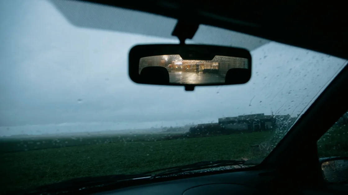 An ADAS forward camera housing mounted to the inside of a windshield behind the rearview mirror.