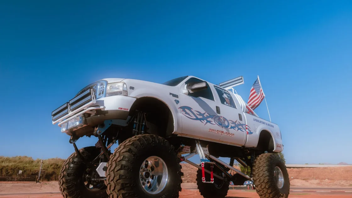 A pickup truck raised on an aftermarket suspension lift kit showing increased ride height and larger tires.