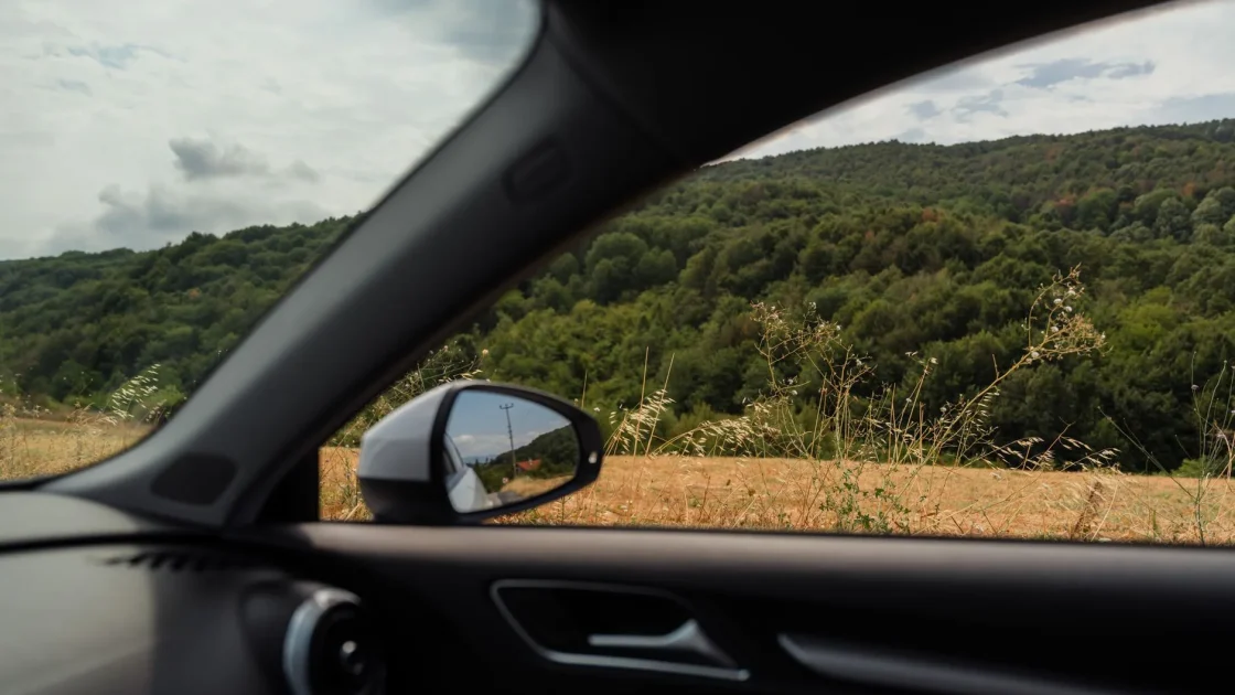 A car side mirror with the blind spot warning indicator visible, tied to the rear corner radar that can switch off