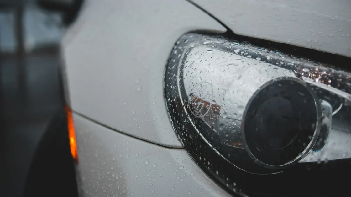 A front radar sensor mounted behind a car's plastic bumper cover, exposed during a repair.