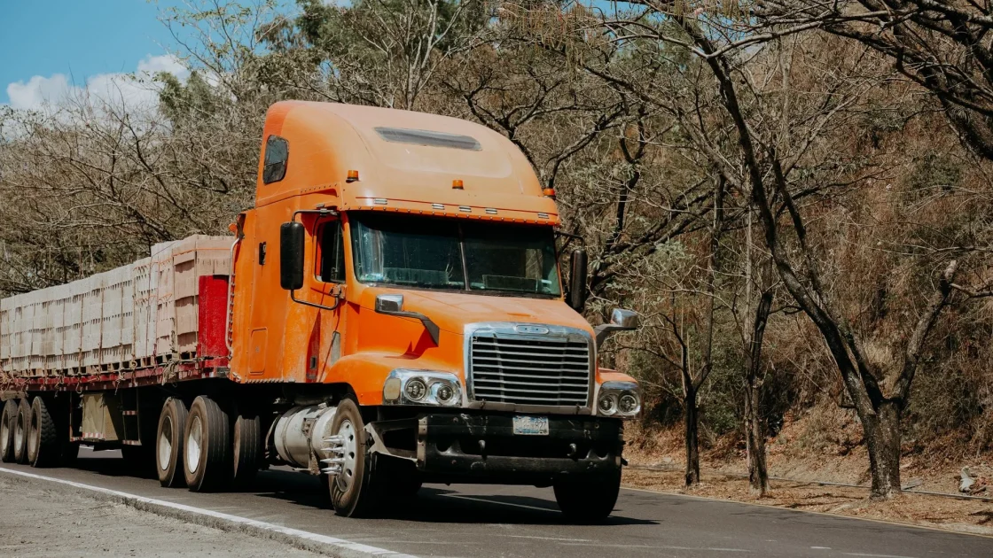 An SUV towing a trailer on a highway with an extended blind spot warning zone illustrated alongside the trailer.