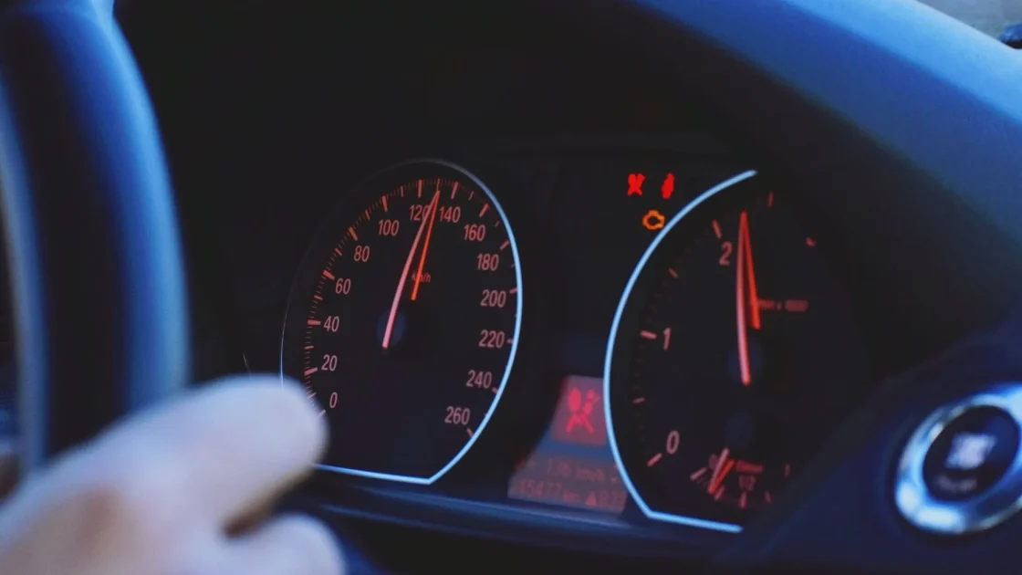 A car dashboard on a highway showing a lane assist indicator that reads the road markings through the windshield camera