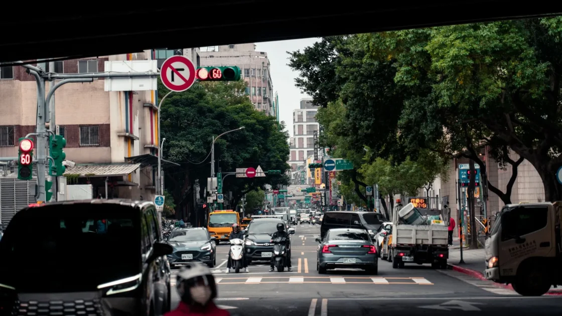 A car preparing to turn left at an intersection with oncoming traffic approaching and a turn-assist warning icon shown on the dashboard.