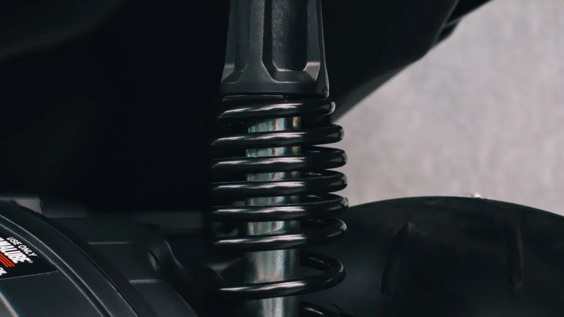 A close-up of a car's front coil spring and strut assembly that sets the vehicle ride height.